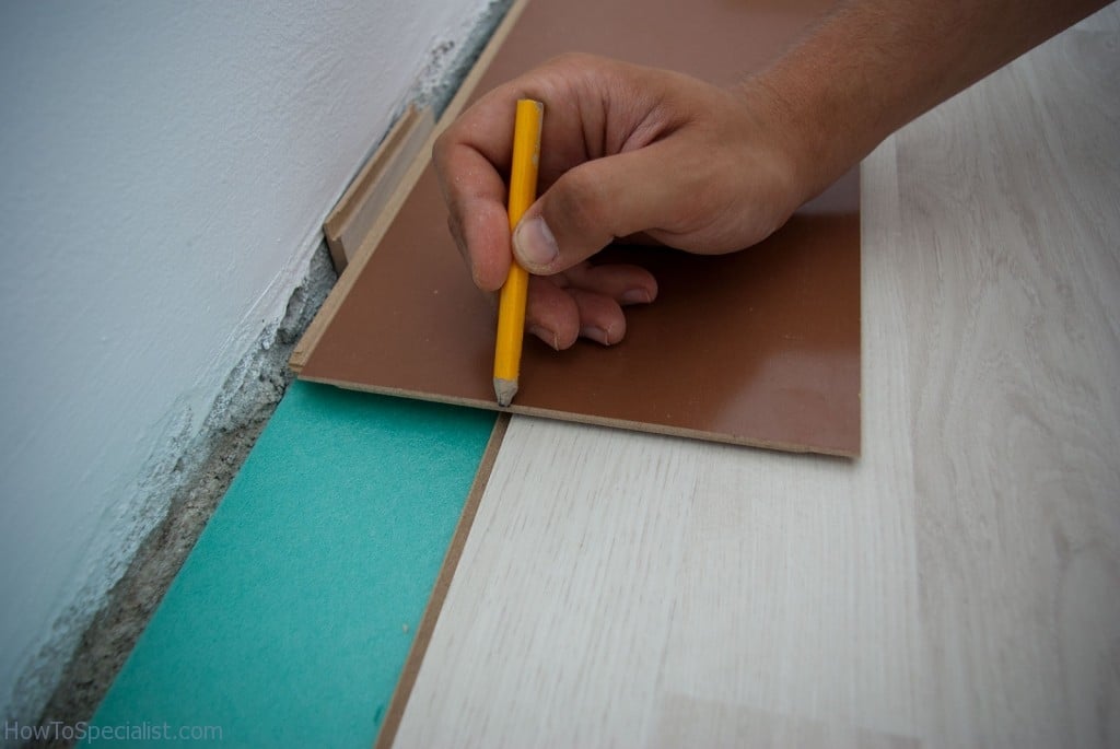 Fitting laminate flooring along wall