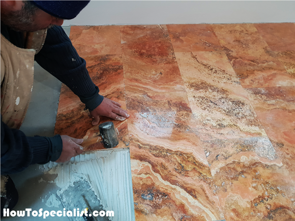 Setting-the-travertine-tiles-with-a-rubber-hammer